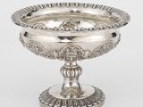 un plateau en argent orné d'un motif décoratif sur le socle