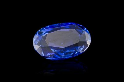 a close up of a blue sapphire on a black surface