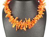 un gros plan d'un collier orné de perles orange sur un mannequin