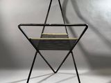 La chaise est en métal et possède une assise tressée.