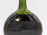 a black and green vase with a red top