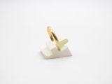 a close up of a gold ring on a white surface