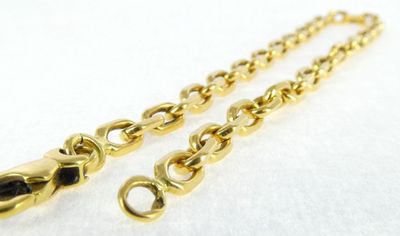 a close up of two gold chains on a white surface