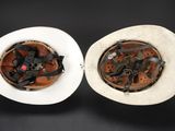 two bowls of food that are on a black table