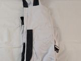 a bag that is laying on a bed with a white sheet