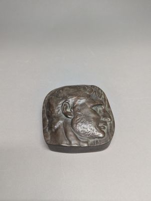 sculpture représentant une tête de lion sur un fond blanc
