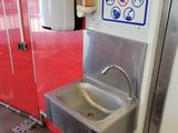 a stainless steel sink in the corner of a public restroom