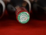several bottles of wine are lined up on a red surface