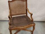 une vieille chaise en bois avec une assise marron et un dossier en rotin
