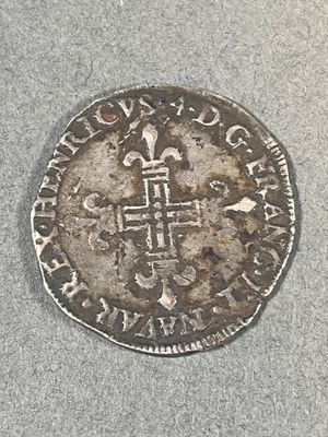 une vieille pièce d'argent ornée d'une croix, posée sur une table