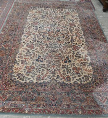 Un tapis persan ancien est posé sur le sol d'une pièce.