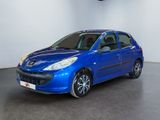 the small blue car is parked in a large room