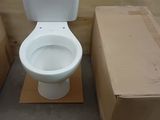 des toilettes blanches posées à côté de cartons dans une pièce