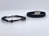 pair of black braided leather bracelets with a silver clasp
