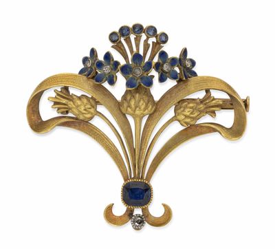 un gros plan sur une broche ornée de fleurs et de feuilles