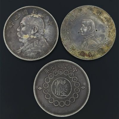 three silver coins with a picture of a man and a woman on them