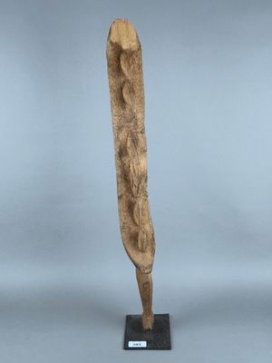 une sculpture en bois représentant la tête d'une femme, posée sur un socle noir