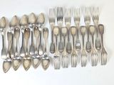 de nombreuses fourchettes et cuillères disposées sur la table