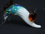 une figurine en verre représentant un chat sur fond noir