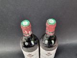 two bottles of wine sitting next to each other on a table