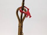 a gold colored cane with a red handle on a white background