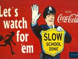 an old coca cola sign advertising a slow school zone