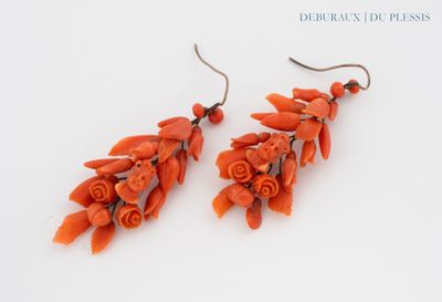 pair of orange coral earrings with silver hooks on a white background