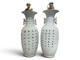 two vases with asian writing on them on a white surface