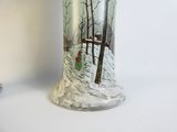 a glass vase with a painting on it sitting on a table