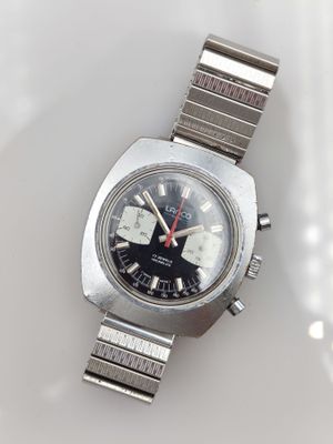 une montre posée sur une surface blanche