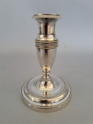 un bougeoir en argent posé sur une table