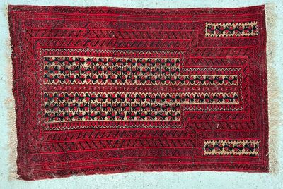 un tapis rouge et noir posé sur une surface blanche