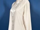 white shirt on a mannequin stand against a blue background
