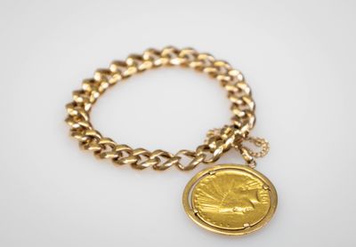 un bracelet en chaîne d'or orné d'une breloque en forme de pièce de monnaie