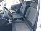 the interior of a small car with black seats and a steering wheel