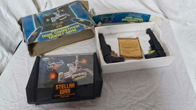 une boîte contenant un pistolet, un livre et un jeu vidéo