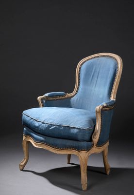 un fauteuil rembourré bleu avec une structure en bois et une assise rembourrée bleue
