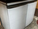 a small white refrigerator sitting in the corner of a room