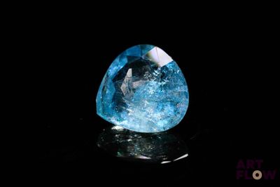 a close up of a blue diamond on a black surface