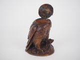 wooden statue of an eagle with a globe on its head