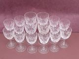 six wine glasses are lined up on a pink surface