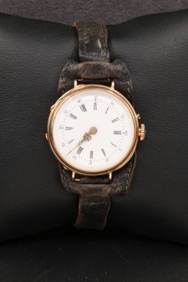 un gros plan d'une montre-bracelet posée sur un coussin noir