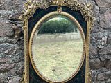 un miroir accroché au mur d'un bâtiment en pierre