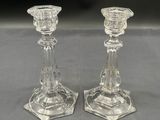 two clear glass candlesticks sitting on top of a table