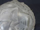 a white sculpture of a face with a knife and fork in it