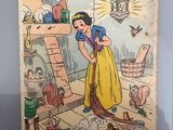 le livre « Blanche-Neige et les sept nains » de Disney, avec l'image d'une femme en robe jaune