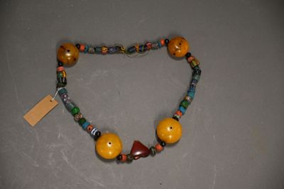 necklace made of wooden beads and glass beads with a tag on it