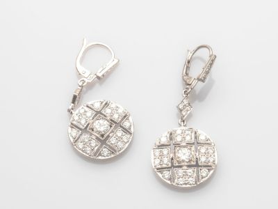 une image d'une paire de boucles d'oreilles en diamant sur fond blanc