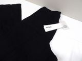 black pants with a white tag on them sitting on a white surface