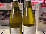 deux bouteilles de vin posées sur une table l'une à côté de l'autre